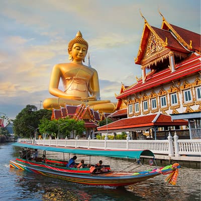 Golden Buddha statue, temple, and a longtail boat in Bangkok