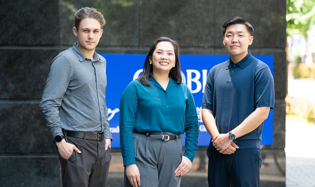 Three professionals standing outside GLOBIS University.
