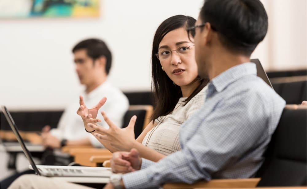 Business professionals engaged in an attentive discussion in a classroom setting