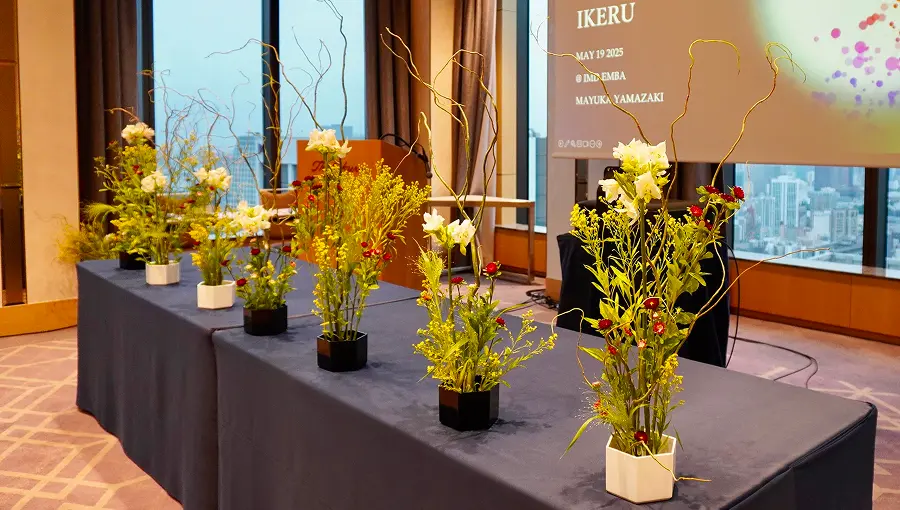 Ikebana flower arrangements displayed on a table during a workshop or presentation.