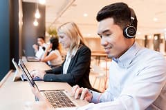 Two learners using laptops to take a business e-learning course