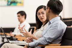 Business professionals engaged in an attentive discussion in a classroom setting