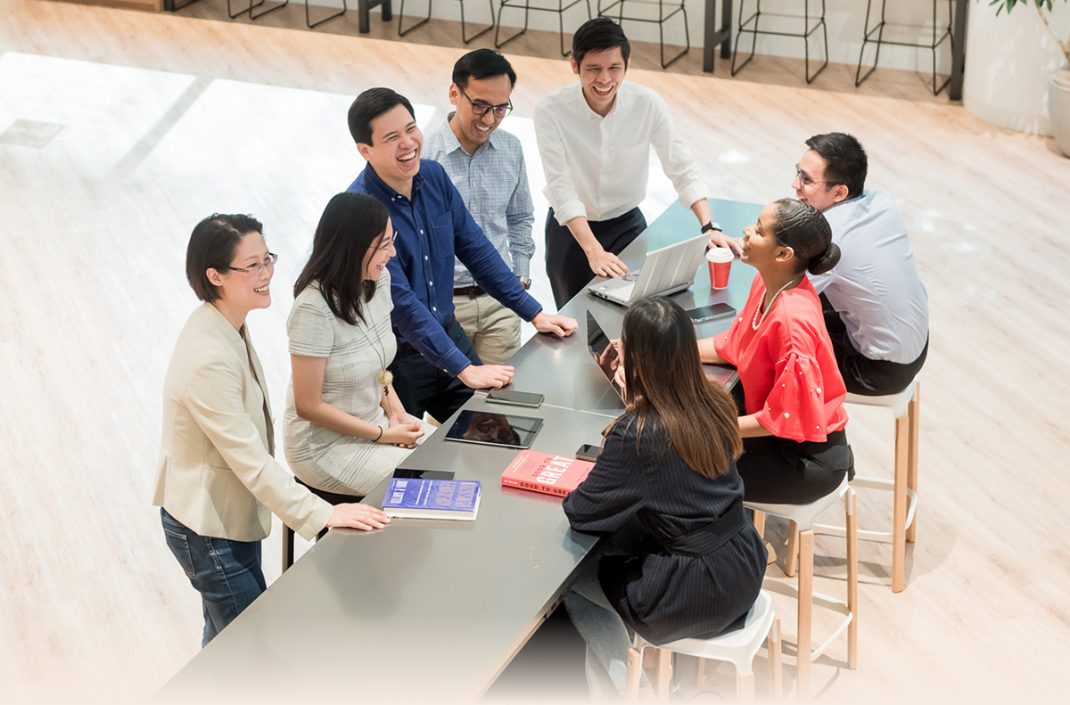 Diverse group of learners engaged in a lively team discussion at the GLOBIS lounge